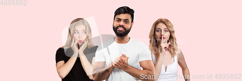 Image of Group portrait of emotional people on coral pink studio background