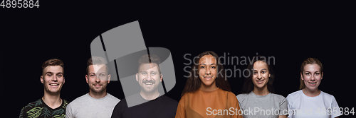 Image of Group portrait of emotional people on black studio background