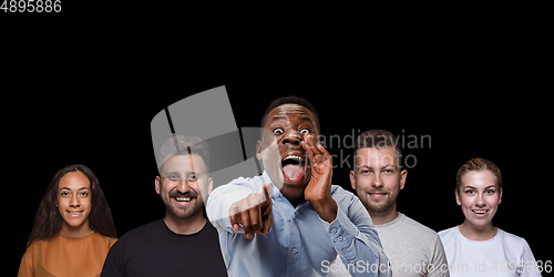 Image of Group portrait of emotional people on black studio background