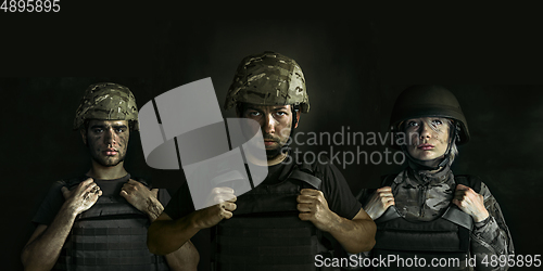 Image of Close up portrait of young soldiers. Men and woman in military uniform on the war, flyer