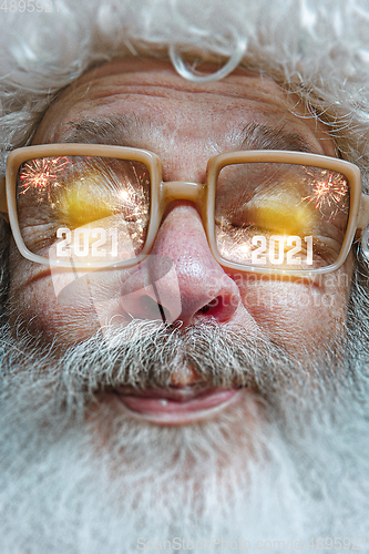 Image of Close up Santa Claus in glasses with a reflection of 2021 Happy New Year