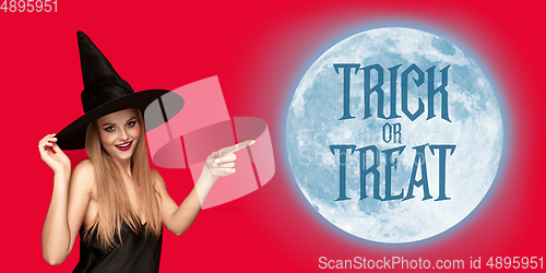 Image of Young woman in hat as a witch on scary red background