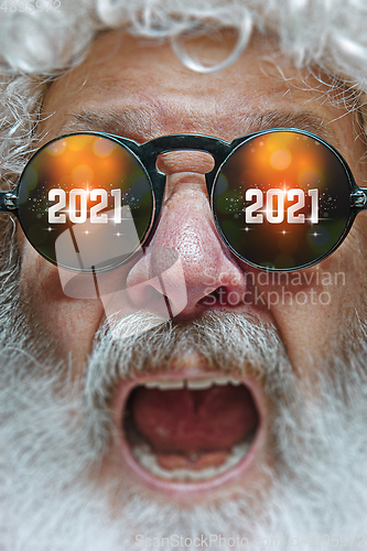 Image of Close up Santa Claus in glasses with a reflection of 2021 Happy New Year