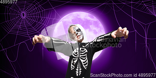 Image of Little kid like vampire with bones on purple background with big moon