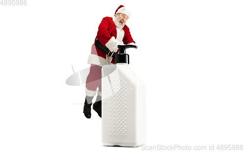 Image of Santa Claus with the huge antiseptics against COVID like Christmas gift isolated on white background