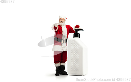 Image of Santa Claus with the huge antiseptics against COVID like Christmas gift isolated on white background