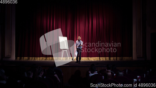 Image of Male caucasian speaker giving presentation in hall at university or business centre workshop