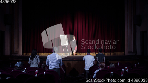 Image of Female caucasian speaker giving presentation in hall at university or business centre workshop