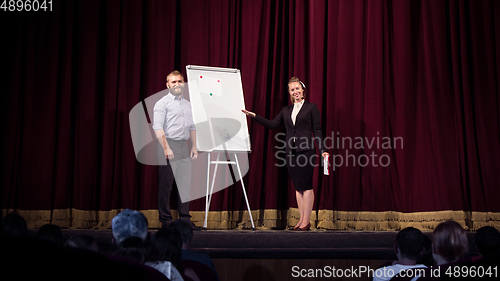 Image of Female caucasian speaker giving presentation in hall at university or business centre workshop