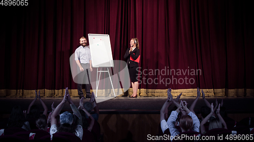 Image of Female caucasian speaker giving presentation in hall at university or business centre workshop