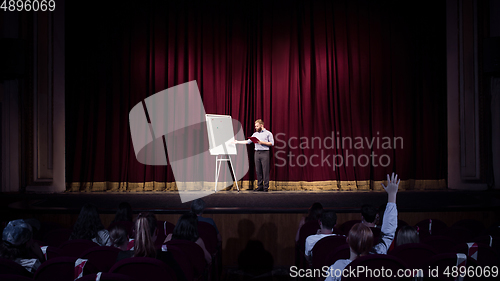 Image of Male caucasian speaker giving presentation in hall at university or business centre workshop