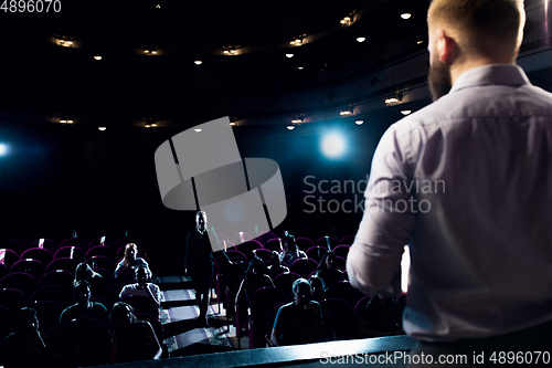 Image of Male caucasian speaker giving presentation in hall at university or business centre workshop