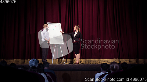 Image of Female caucasian speaker giving presentation in hall at university or business centre workshop