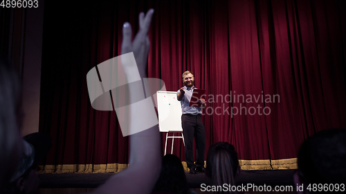 Image of Male caucasian speaker giving presentation in hall at university or business centre workshop