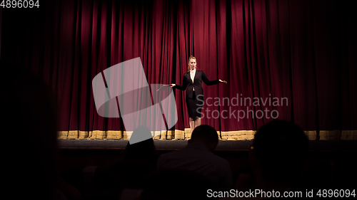 Image of Female caucasian speaker giving presentation in hall at university or business centre workshop