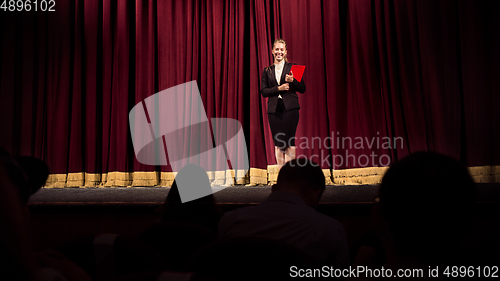 Image of Female caucasian speaker giving presentation in hall at university or business centre workshop