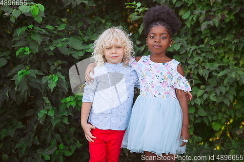 Image of Interracial kids, friends, girl and boy playing together at the park in summer day