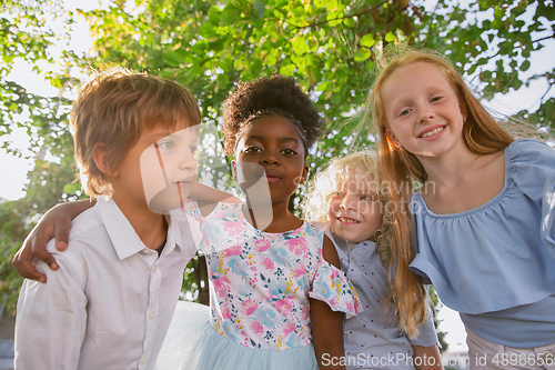 Image of Interracial group of kids, girls and boys playing together at the park in summer day