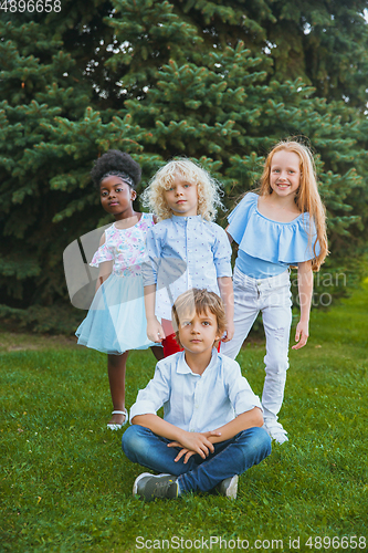 Image of Interracial group of kids, girls and boys playing together at the park in summer day