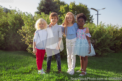 Image of Interracial group of kids, girls and boys playing together at the park in summer day