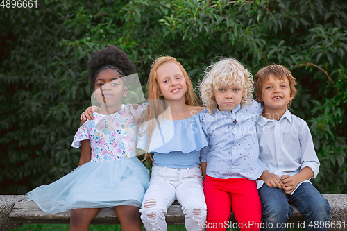 Image of Interracial group of kids, girls and boys playing together at the park in summer day