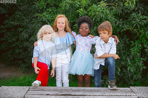 Image of Interracial group of kids, girls and boys playing together at the park in summer day