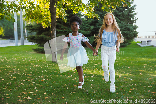 Image of Interracial kids, friends, girls playing together at the park in summer day