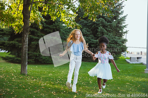 Image of Interracial kids, friends, girls playing together at the park in summer day