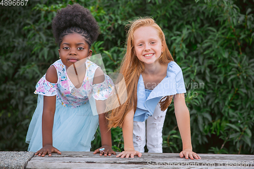 Image of Interracial kids, friends, girls playing together at the park in summer day