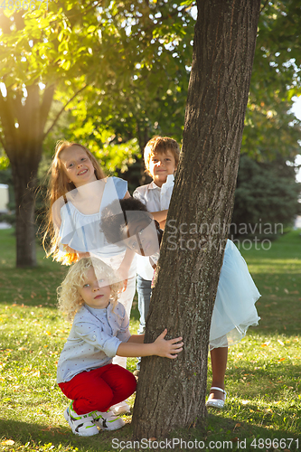 Image of Interracial group of kids, girls and boys playing together at the park in summer day