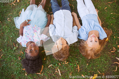 Image of Interracial group of kids, girls and boys playing together at the park in summer day