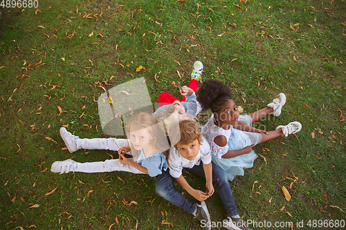 Image of Interracial group of kids, girls and boys playing together at the park in summer day