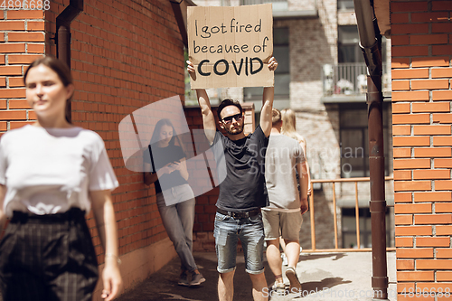 Image of Dude with sign - man stands protesting things that annoy him