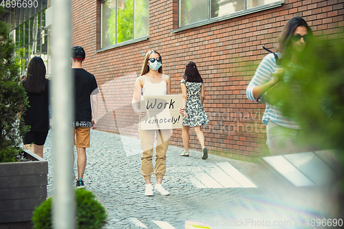 Image of Dude with sign - woman stands protesting things that annoy him