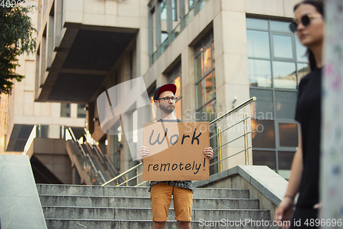 Image of Dude with sign - man stands protesting things that annoy him