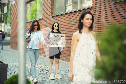 Image of Dude with sign - woman stands protesting things that annoy him