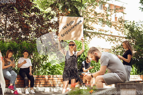 Image of Dude with sign - woman stands protesting things that annoy him