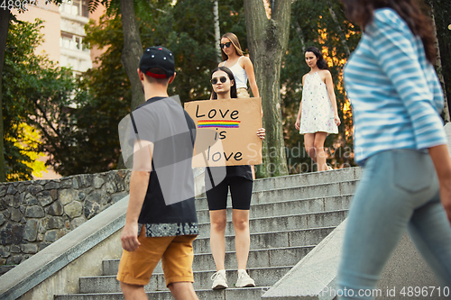 Image of Dude with sign - woman stands protesting things that annoy him