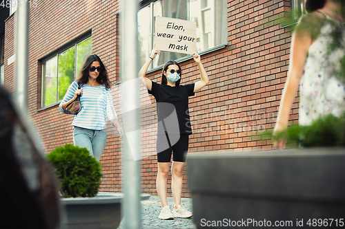 Image of Dude with sign - woman stands protesting things that annoy him