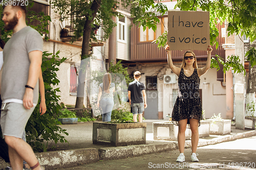 Image of Dude with sign - woman stands protesting things that annoy him