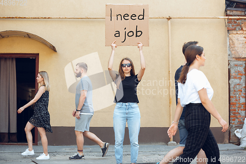 Image of Dude with sign - woman stands protesting things that annoy him