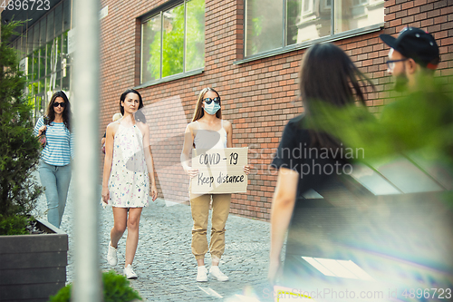 Image of Dude with sign - woman stands protesting things that annoy him