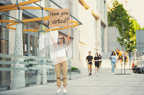 Image of Dude with sign - woman stands protesting things that annoy him