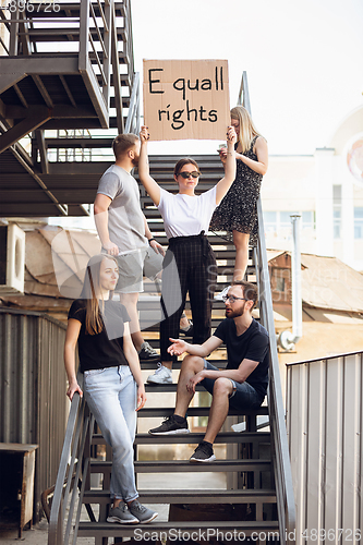 Image of Dude with sign - woman stands protesting things that annoy him