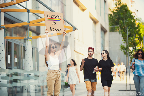 Image of Dude with sign - woman stands protesting things that annoy him