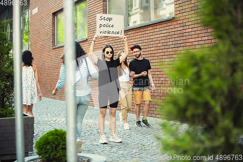 Image of Dude with sign - woman stands protesting things that annoy him