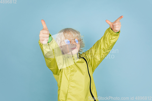 Image of Portrait of beautiful caucasian little boy isolated on blue studio background