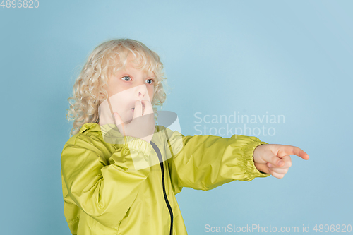 Image of Portrait of beautiful caucasian little boy isolated on blue studio background