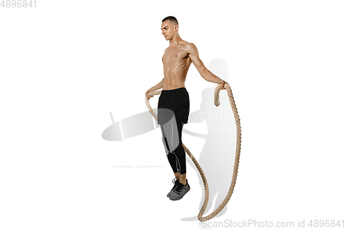 Image of Beautiful young male athlete practicing on white studio background with shadows