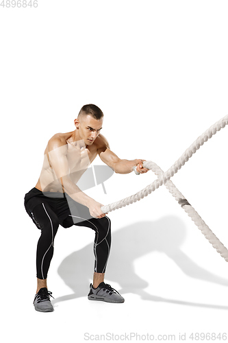 Image of Beautiful young male athlete practicing on white studio background with shadows